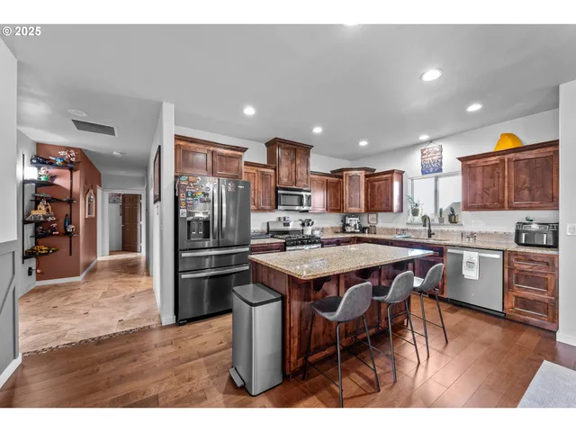 a kitchen with stainless steel appliances granite countertop a refrigerator and a stove top oven