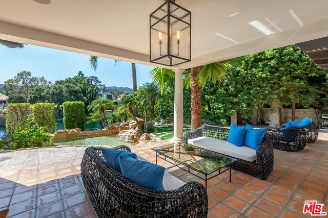 a large white kitchen with kitchen island a stove a sink a refrigerator and white cabinets with wooden floor