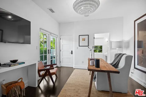 a living room with patio furniture and a potted plant