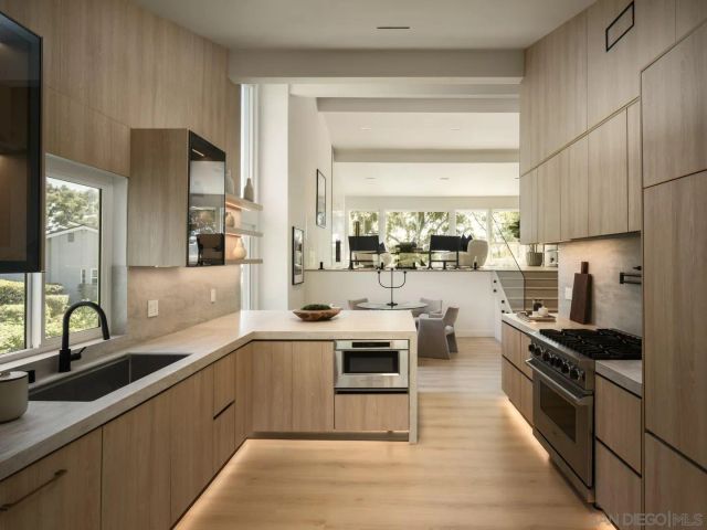a kitchen with stainless steel appliances a sink stove and cabinets