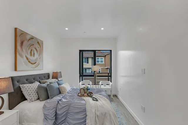 a bed room with a bed and painting on the wall