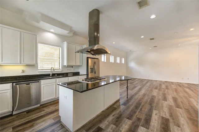 a kitchen with granite countertop a sink stainless steel appliances and window