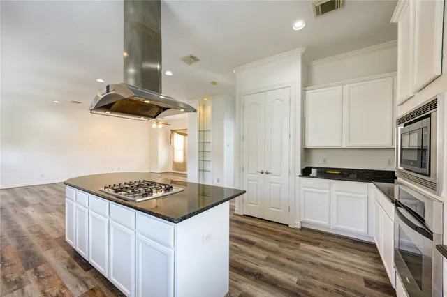 a kitchen with stainless steel appliances granite countertop a sink stove and cabinets