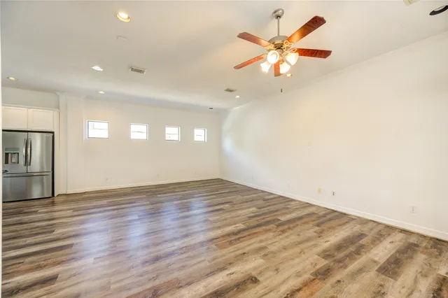 a view of an empty room with window and wooden floor