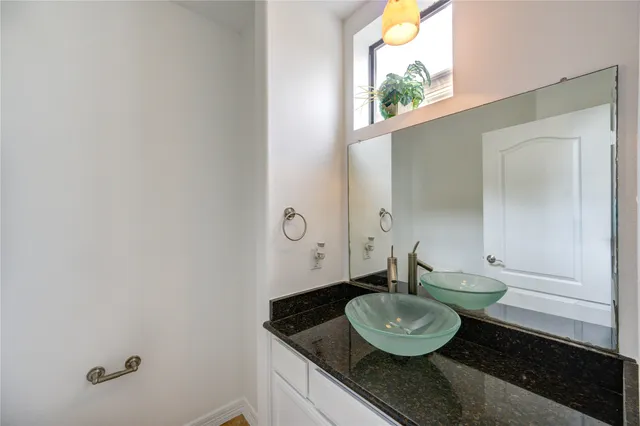 a bathroom with a granite countertop sink and a mirror