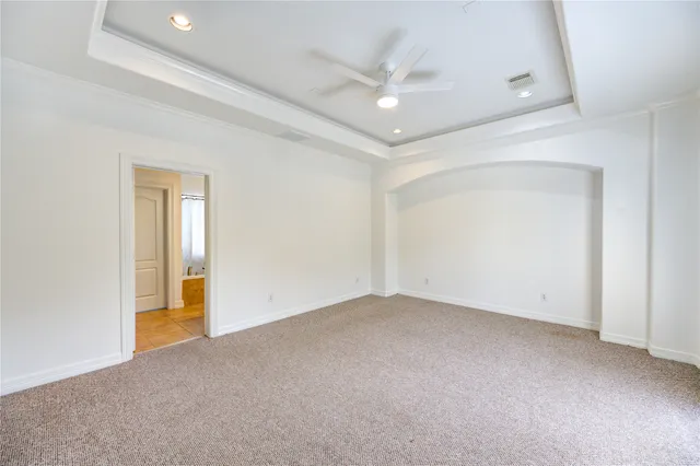 an empty room with a ceiling fan and closet area