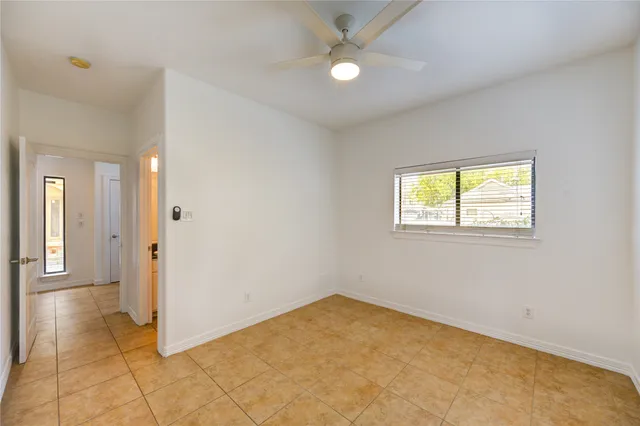 an empty room with a ceiling fan and a window