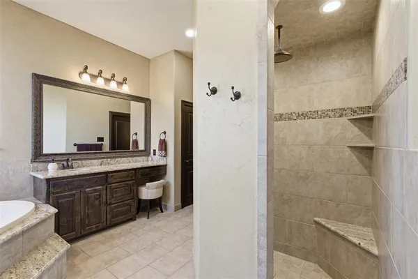 a spacious bathroom with a granite countertop sink and a mirror