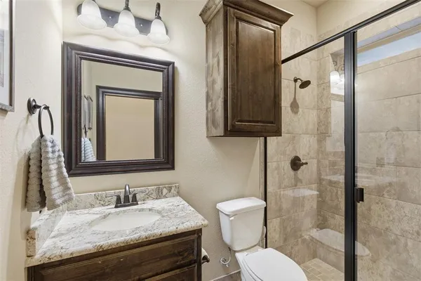a bathroom with a granite countertop tub sink and mirror