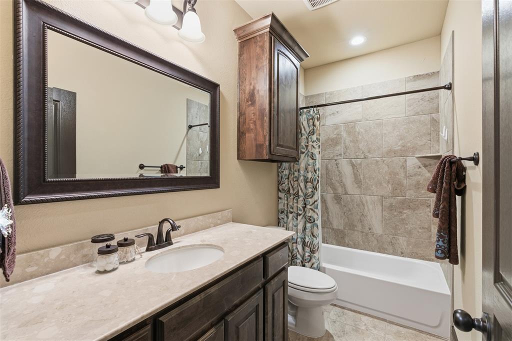 6298 Belz Road Sanger, TX 76266 - Photo 22 of 40 a bathroom with a granite countertop sink toilet mirror and shower