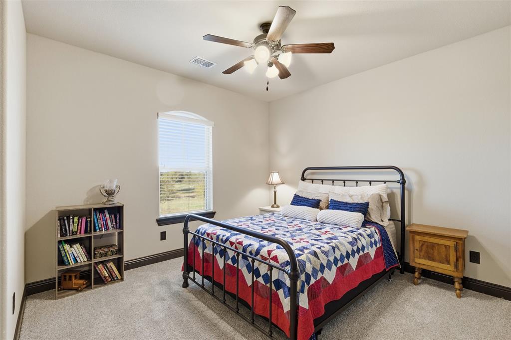 6298 Belz Road Sanger, TX 76266 - Photo 23 of 40 a bedroom with a bed and a chandelier