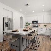 a kitchen with stainless steel appliances kitchen island granite countertop a kitchen island hardwood floor and a sink