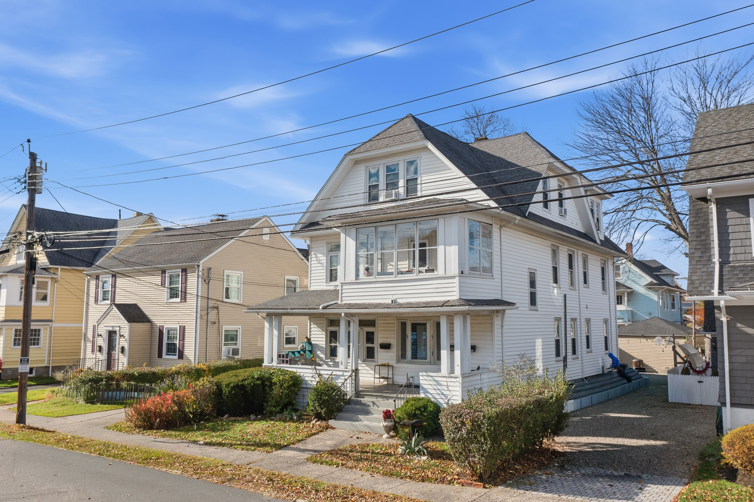 a view of a white building among the street with palm trees