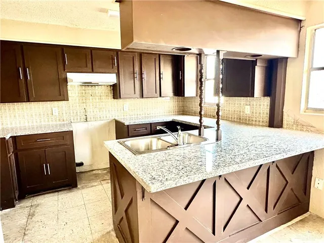 a kitchen with stainless steel appliances kitchen island granite countertop a sink and cabinets