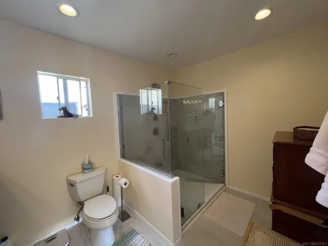 a bathroom with a granite countertop toilet a sink and shower