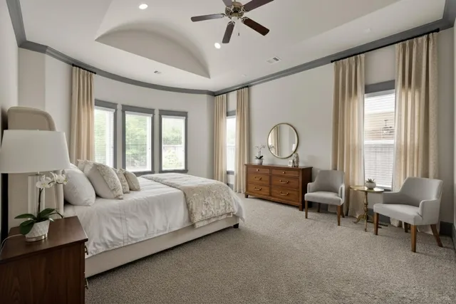 a bedroom with a bed couches and a flat tv screen