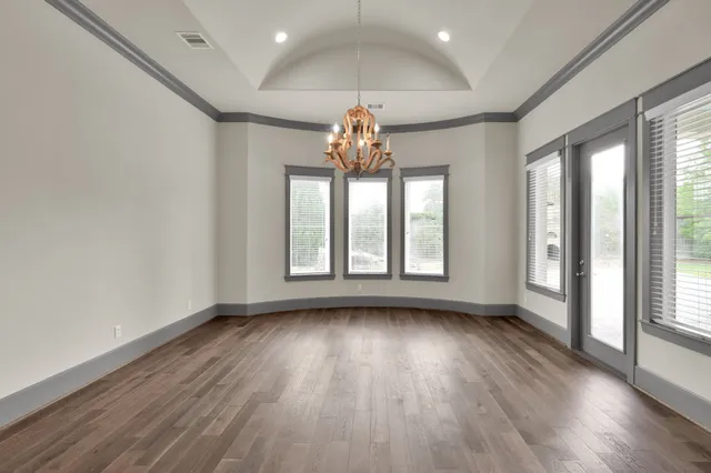 a very nice looking room with wooden floor chandeliers and window