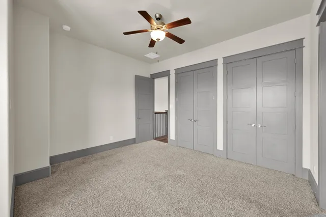 a view of an empty room and a ceiling fan