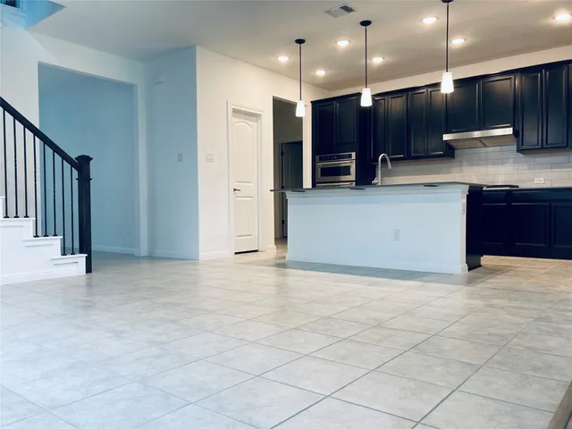 a view of kitchen with refrigerator and microwave
