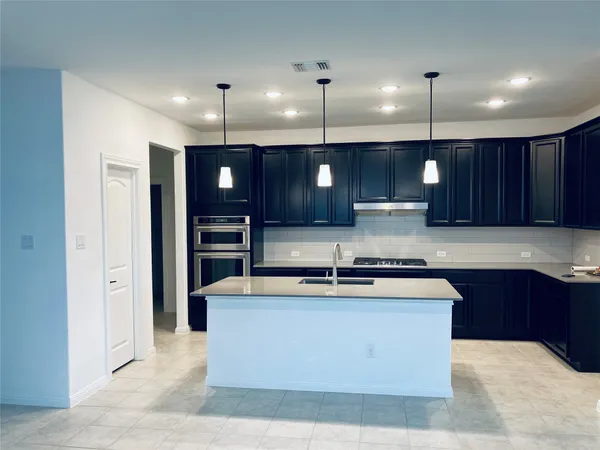 a large kitchen with kitchen island a large island in the center