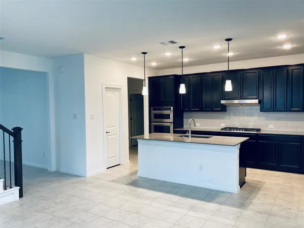 a large kitchen with stainless steel appliances granite countertop a stove a sink and a refrigerator