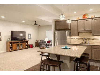 a kitchen with stainless steel appliances a dining table chairs stove and refrigerator