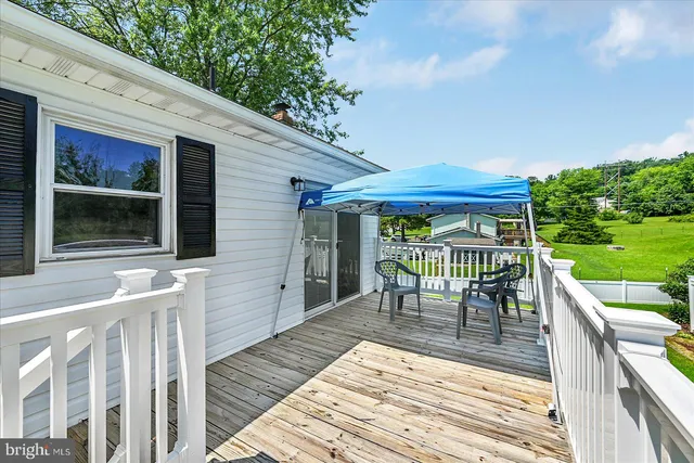 a large kitchen with stainless steel appliances granite countertop a stove top oven a sink dishwasher a dining table and chairs with wooden floor