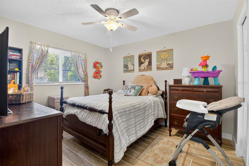 1632 Amstead Street Punta Gorda, FL 33980 - Photo 23 of 50 a bedroom with a bed a desk and chair with a large mirror on the dresser