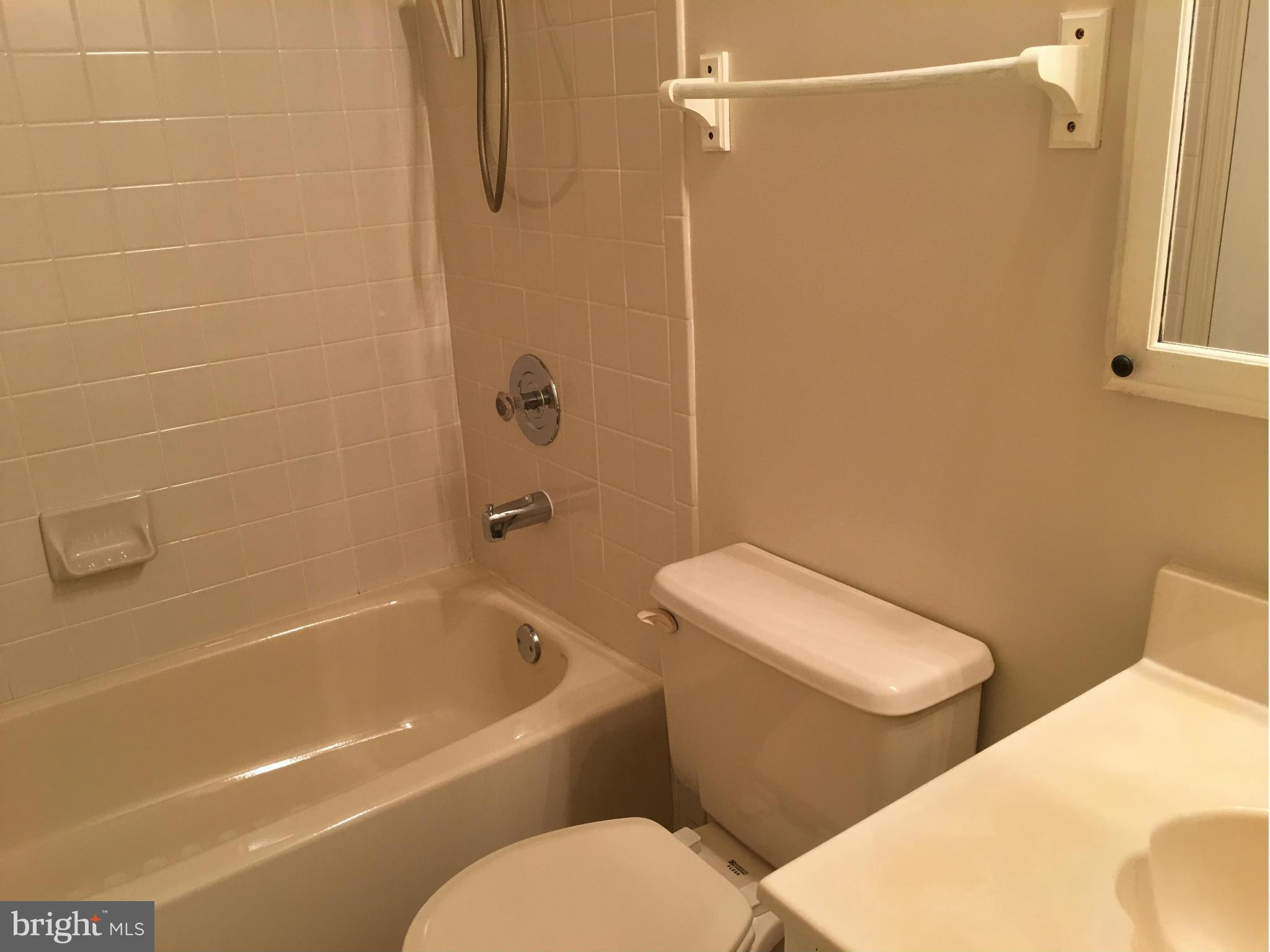 7482 Wounded Knee Road Lorton, VA 22079 - Photo 17 of 29 a white toilet and tub sitting next to a bathroom sink