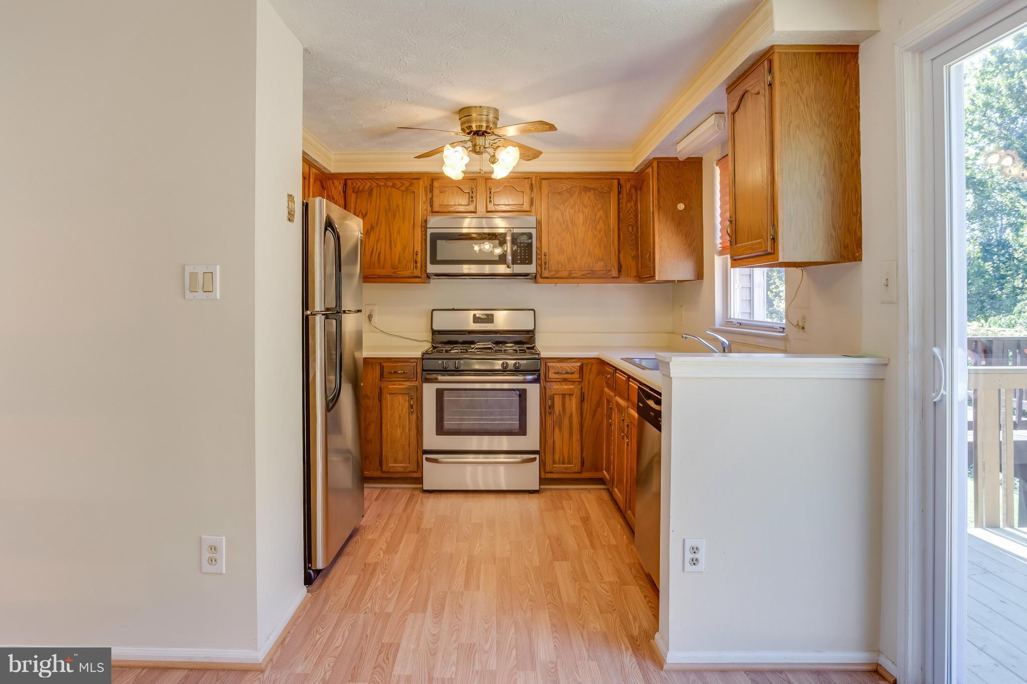 7482 Wounded Knee Road Lorton, VA 22079 - Photo 8 of 29 a kitchen with stainless steel appliances a refrigerator and a stove top oven