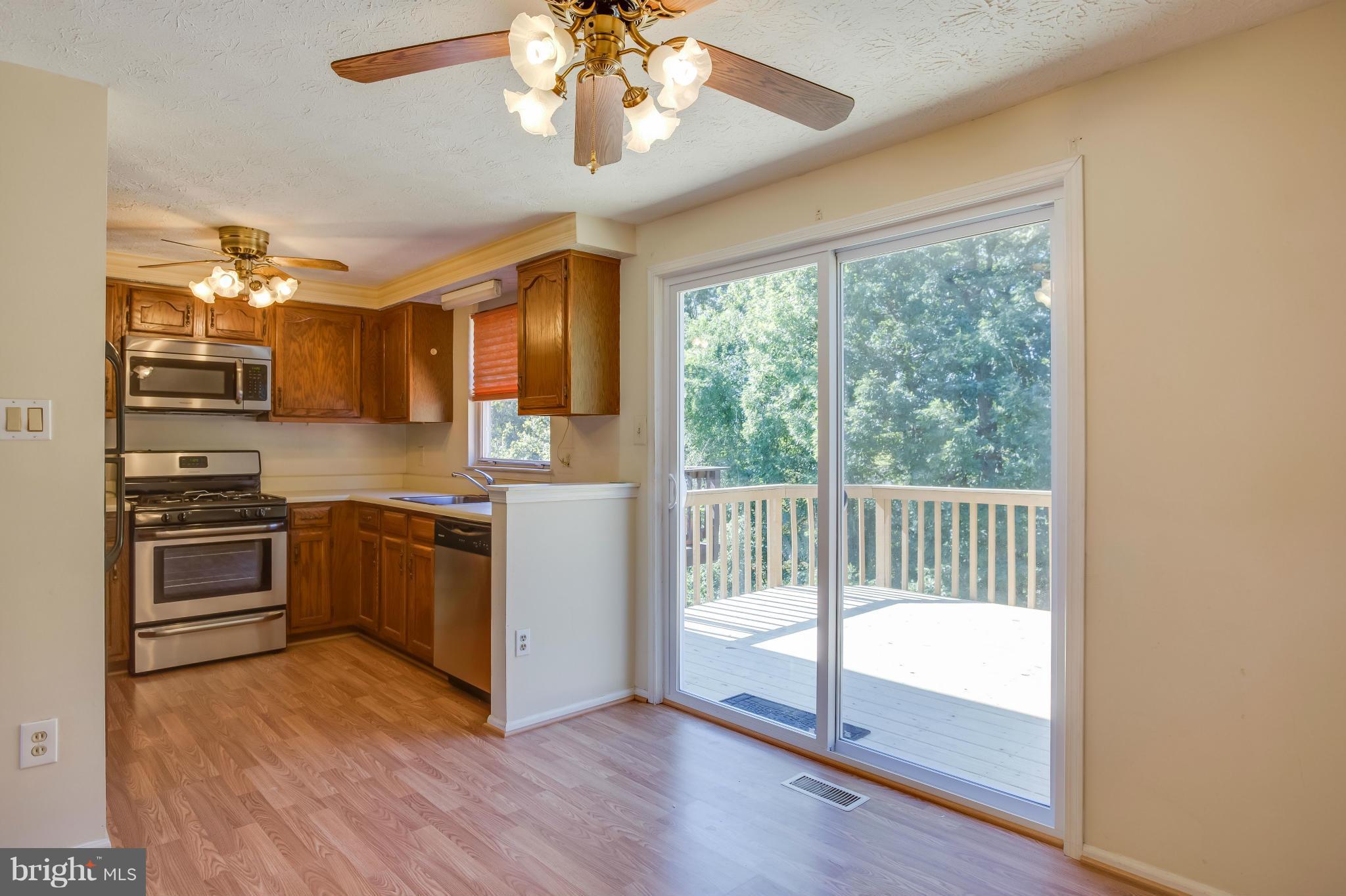 7482 Wounded Knee Road Lorton, VA 22079 - Photo 9 of 29 a kitchen with stainless steel appliances granite countertop a stove top oven a sink and cabinets