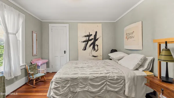 a bedroom with a bed dresser and a flat screen tv