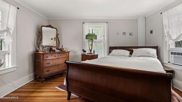 a bedroom with a bed and wooden floor
