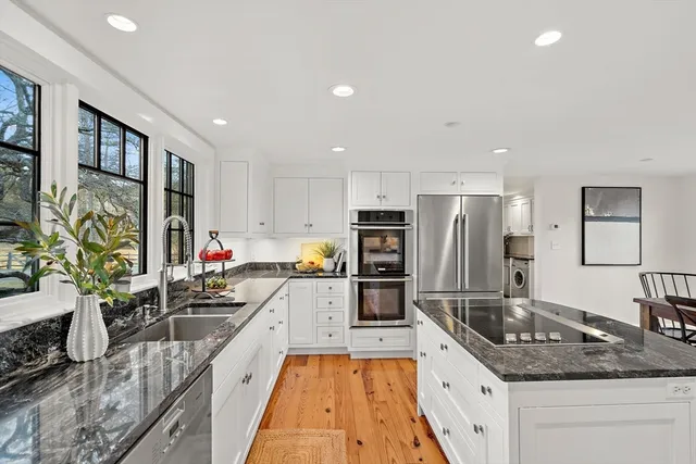 a kitchen with stainless steel appliances granite countertop a sink stove and refrigerator