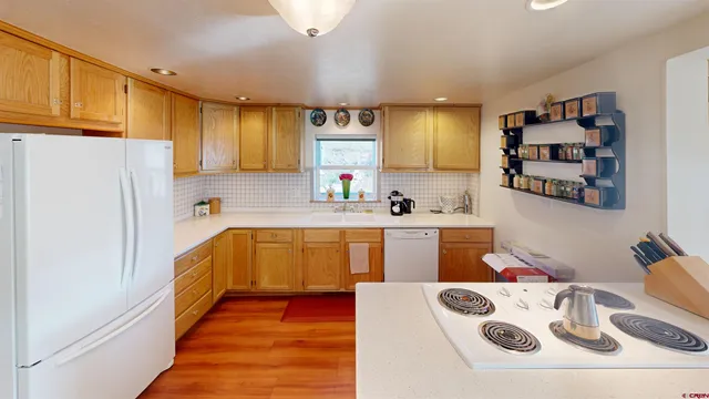 a kitchen with stainless steel appliances a refrigerator and a wooden floor