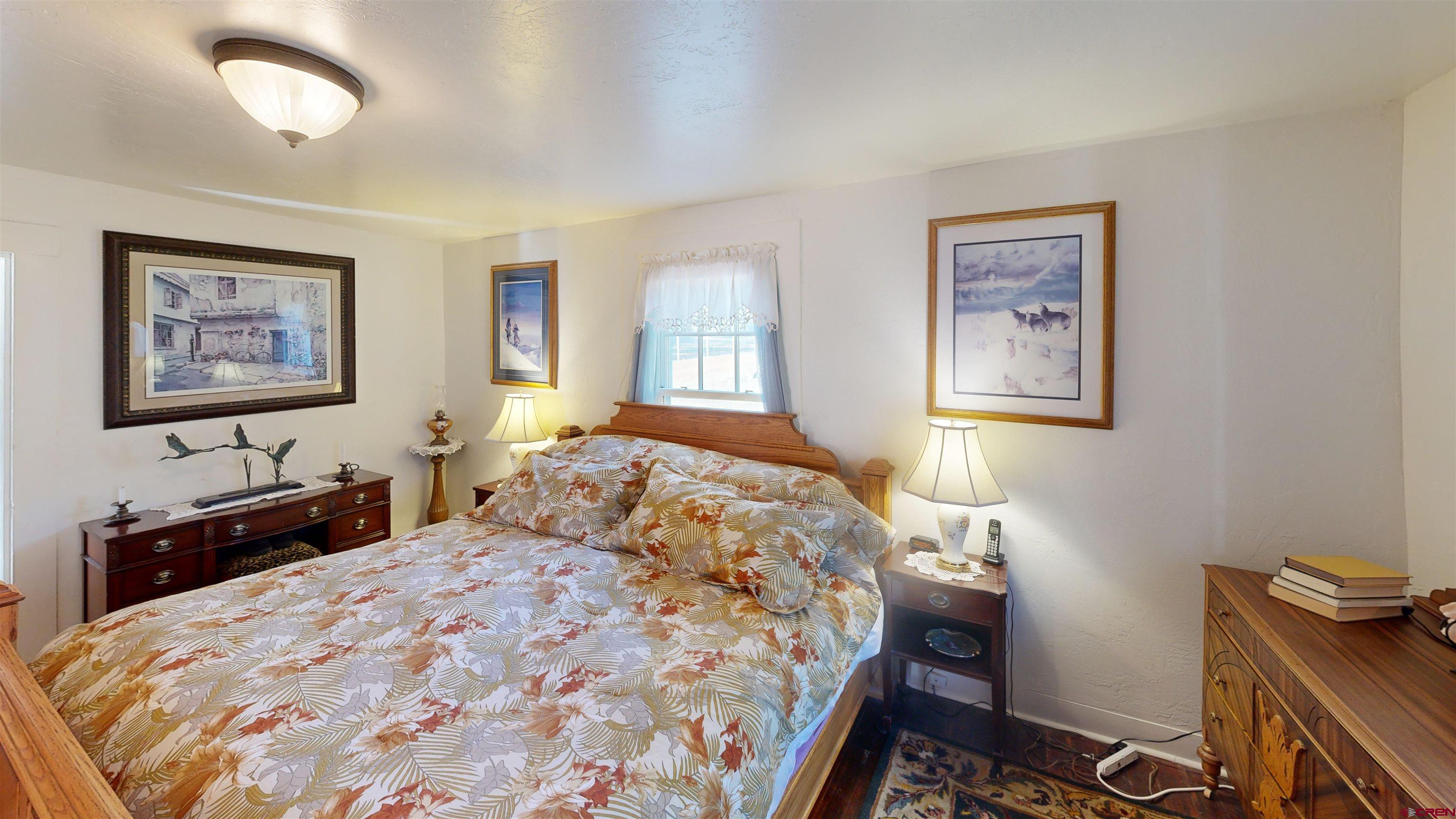 16431 Highway 149 Powderhorn, CO 81243 - Photo 21 of 24 a bedroom with a bed and a dresser