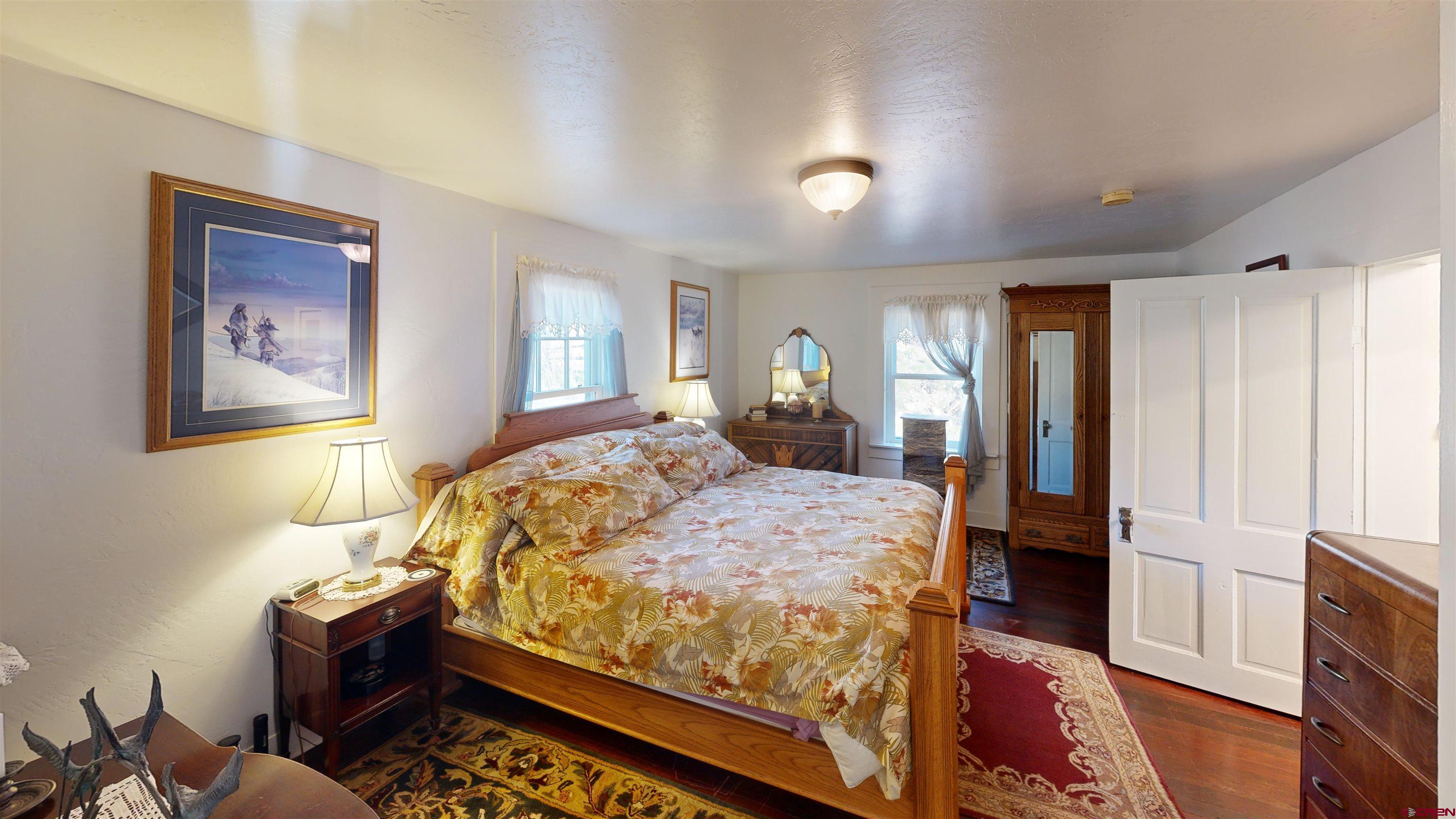 16431 Highway 149 Powderhorn, CO 81243 - Photo 22 of 24 a bed sitting in a spacious bedroom next to a window