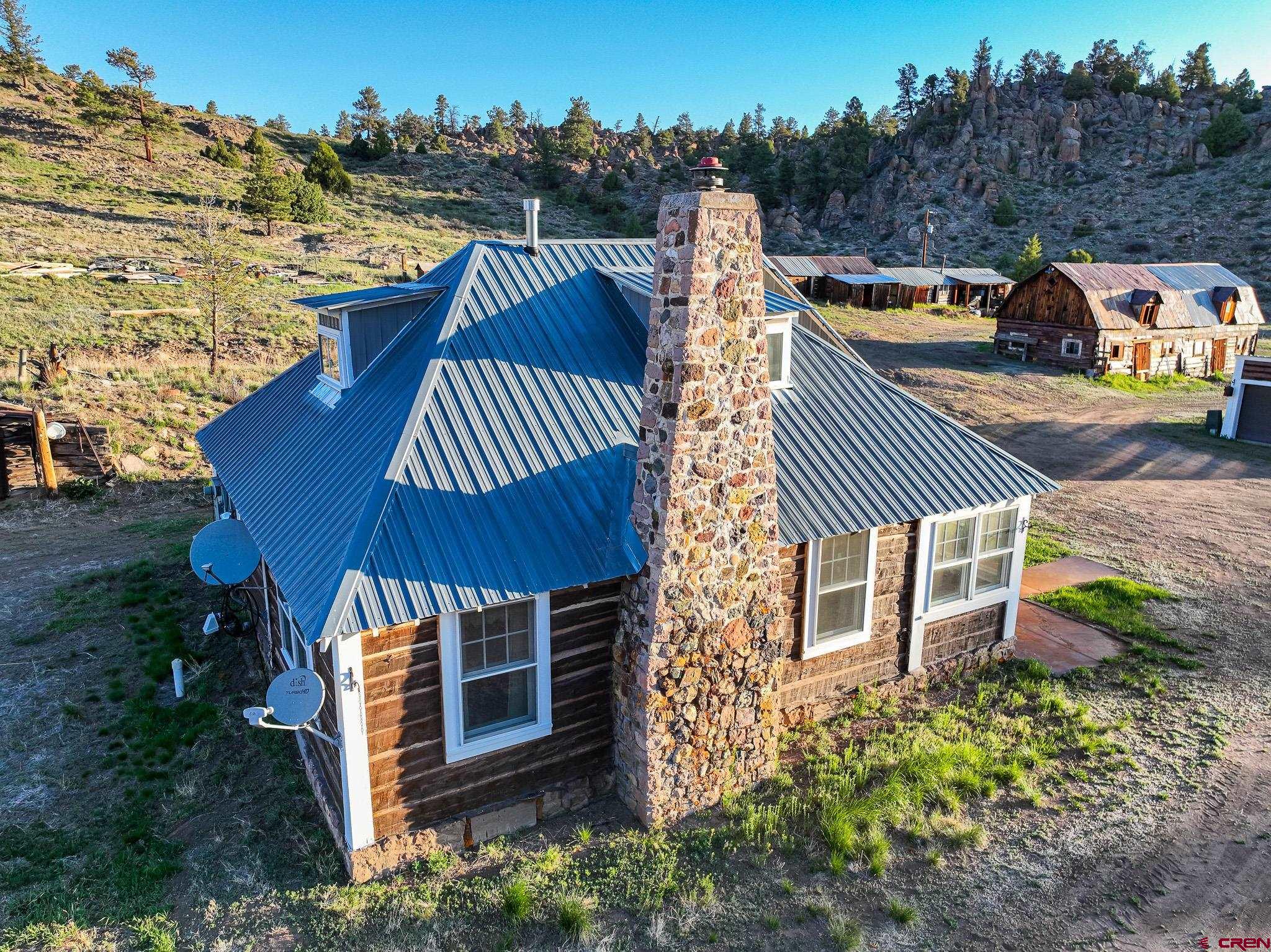 16431 Highway 149 Powderhorn, CO 81243 - Photo 3 of 24 a view of a roof deck with table and chairs a barbeque with wooden floor and city view