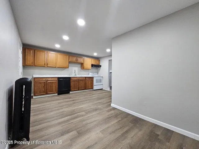 a view of kitchen with granite countertop cabinets and refrigerator