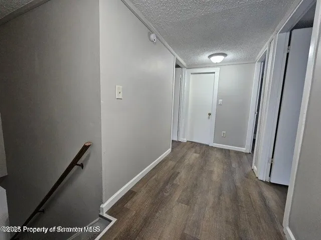 a view of hallway with wooden floor