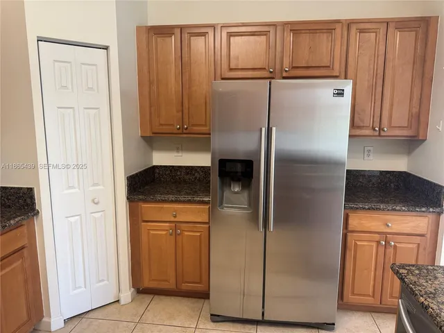a kitchen with granite countertop a stove top oven microwave and cabinets