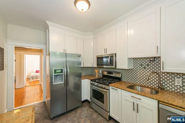 a kitchen with stainless steel appliances granite countertop a refrigerator and a stove