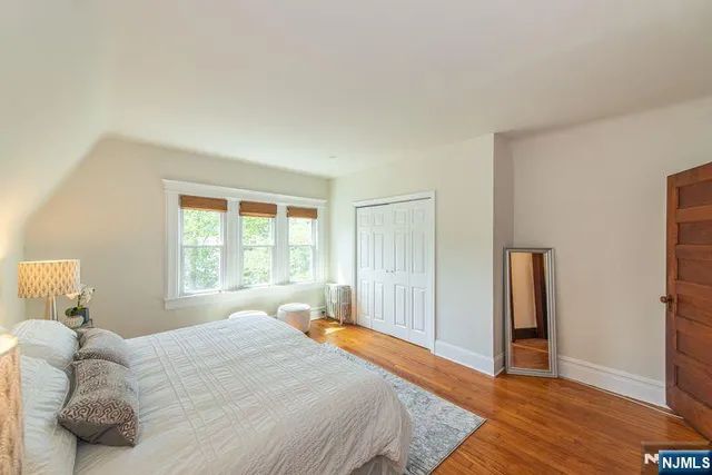 a bedroom with a bed and wooden floor