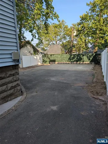 a view of a patio with table and chairs potted plants and a large tree