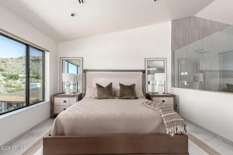 a large bed sitting in a bedroom next to a large window
