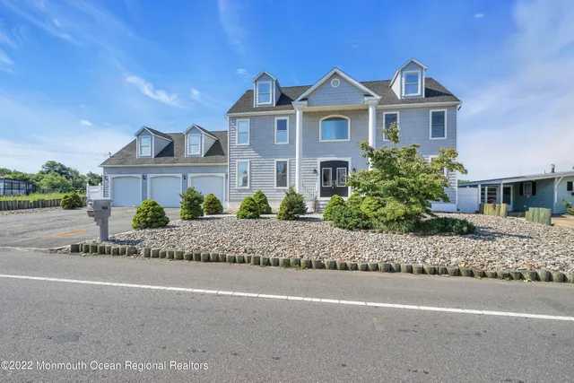 a front view of a house with a yard and potted plants