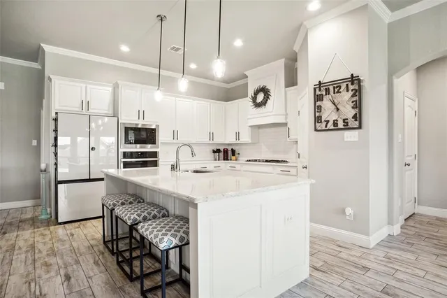 a kitchen with stainless steel appliances kitchen island a refrigerator sink and cabinets