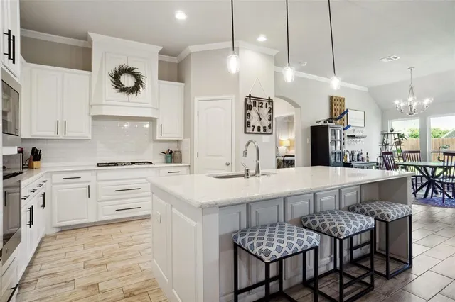 a kitchen with granite countertop a sink a stove and cabinets