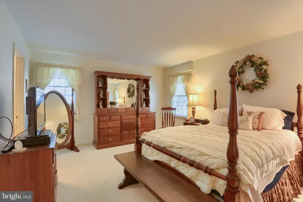 a bedroom with a bed and dresser with mirror