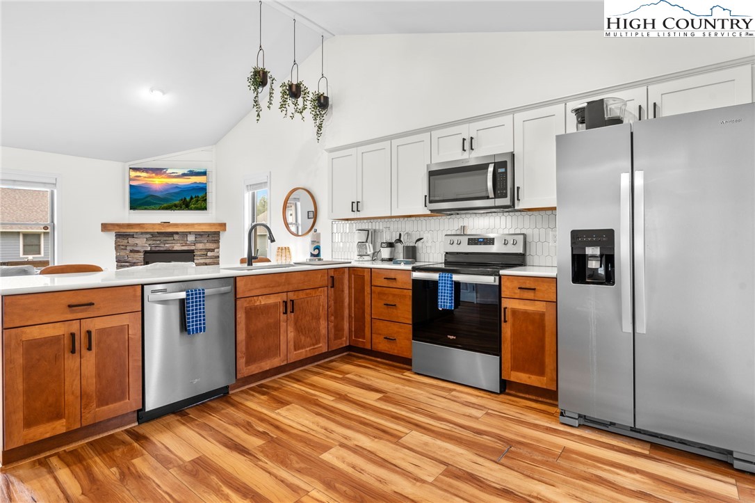 429 Townhomes Place, Unit 18 Boone, NC 28607 - Photo 7 of 25 a kitchen with stainless steel appliances granite countertop a refrigerator a sink dishwasher a oven with white cabinets and wooden floor